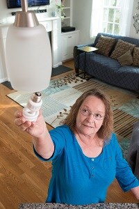 Lillian Racicot reaching for a light bulb after successful shoulder surgery